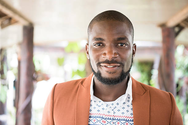Attractive young African man looking at camera. Contented young man with facial hair and moustache facing camera, Nigeria, Africa.